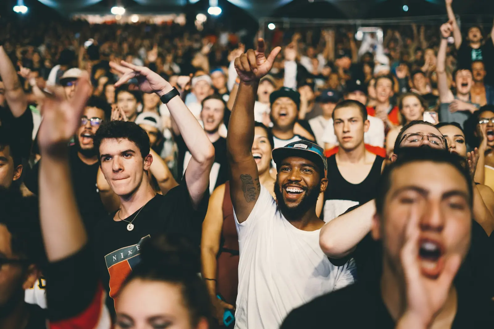 A crowd with raised hands at a live concert
