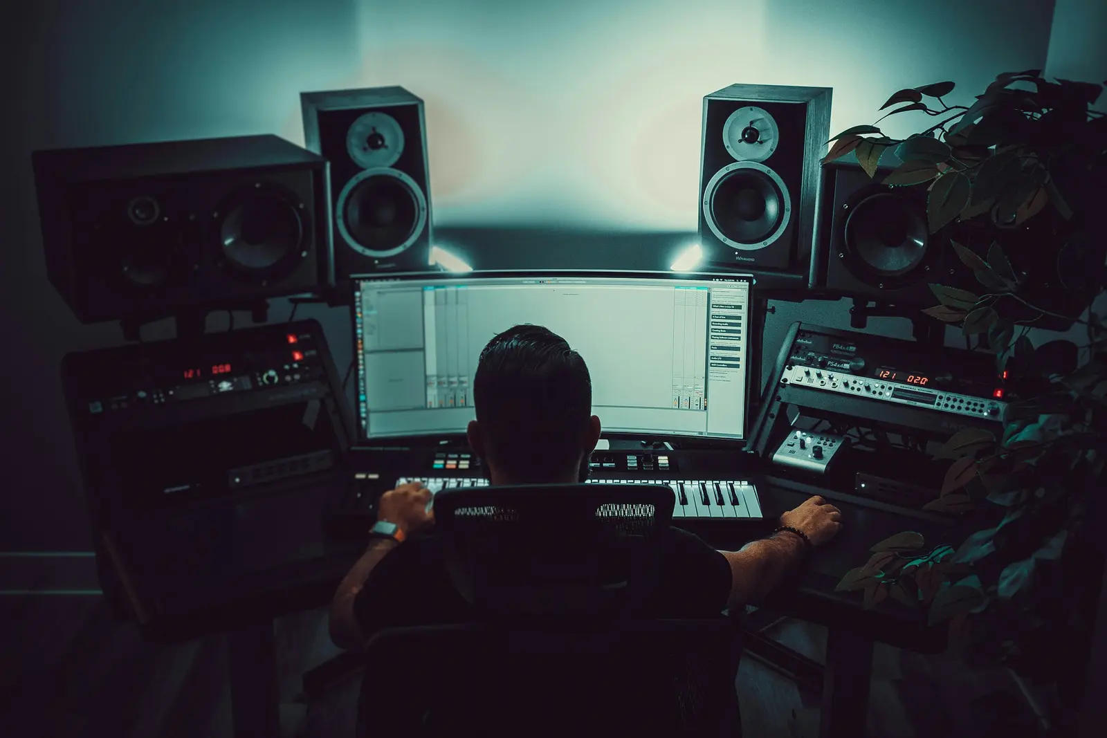 A producer at a mixing desk between studio monitors